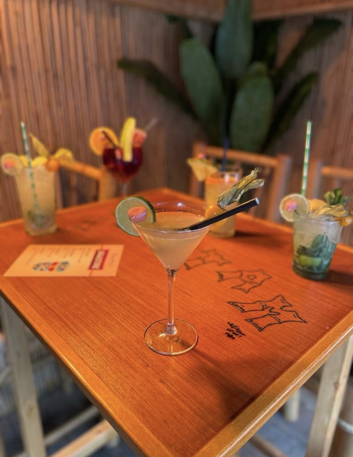 Cocktail servi sur une table en bois dans le décor bambou du Tam-Tam Bambou